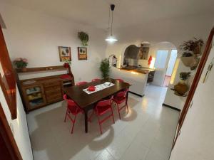 埃尔戈尔福Casa Leyna的厨房以及带桌子和红色椅子的用餐室。