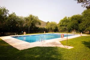 Villaviciosa de CórdobaBungalows Camping Jimmy Jones的草地上的游泳池