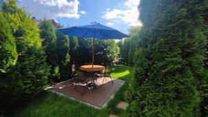 佩霍维采Apartamenty Tuwima的花园内桌椅和遮阳伞