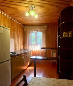 舍绍里Садиба Анастасія的厨房设有木墙、桌子和窗户。