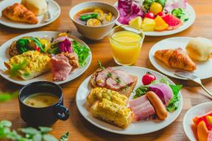 札幌北海道札幌大通柔婕阁酒店的一张木桌,上面放着早餐食品和饮料