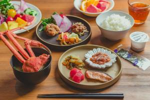 札幌北海道札幌大通柔婕阁酒店的餐桌,盘子上放着食物和碗