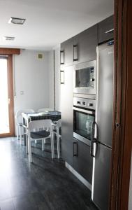 贝梅奥Maiala Etxea Terraza-Parking-Wifi GRATIS Zona nueva的厨房配有冰箱和桌椅