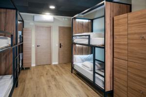 瓦伦西亚SOM Hostel By The Venue的客房设有四张双层床和木制橱柜。