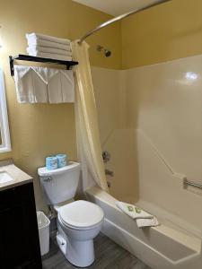 北康威瑞士小屋村旅馆的浴室配有卫生间、浴缸和水槽。