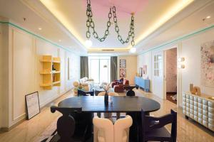 茉莉芬Sonar Paraiso: A Dreamy Apartment in Jakarta的客厅配有桌椅和吊灯。