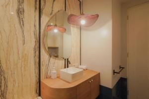 茉莉芬Sonar Paraiso: A Dreamy Apartment in Jakarta的一间带水槽和镜子的浴室
