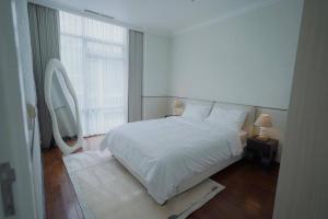 茉莉芬Sonar Paraiso: A Dreamy Apartment in Jakarta的卧室设有白色的床和大窗户