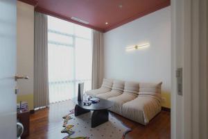 茉莉芬Sonar Paraiso: A Dreamy Apartment in Jakarta的客厅配有沙发和桌子