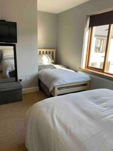 穆尔兰尼Sea Breeze Cottage Mulranny的一间卧室配有两张床和一台平面电视
