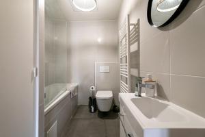 佩皮尼昂Perpignan - Appartement en centre ville的白色的浴室设有浴缸、盥洗盆和卫生间。