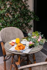 巴黎Snob Hotel的一张桌子上放着一盘羊角面包和水果
