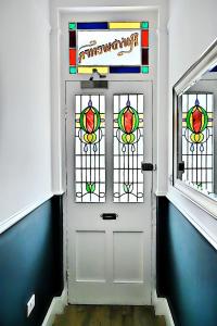 波特马多克Porthmadog, Sleeps 11, 5 Bedrooms, 5 Bathrooms, Mountain Views的走廊上设有彩色玻璃窗的白色门