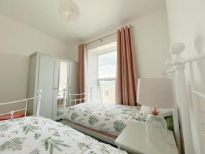 波特马多克Porthmadog, Sleeps 11, 5 Bedrooms, 5 Bathrooms, Mountain Views的一间卧室设有两张床和窗户。