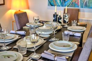 克劳奇河畔伯纳姆Finest Retreats - Kings Wharf - Luxury Riverside Home的一张桌子上放有盘子和酒杯