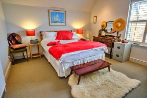 克劳奇河畔伯纳姆Finest Retreats - Kings Wharf - Luxury Riverside Home的一间卧室配有一张带红色毯子的大床