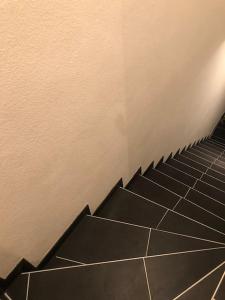 明斯特Eine 2 Zimmer Ferienwohnung Münster City的楼梯,浴室有黑色瓷砖