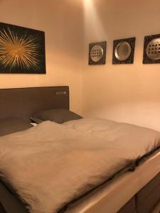 明斯特Eine 2 Zimmer Ferienwohnung Münster City的卧室内的一张床铺,墙上有三幅画