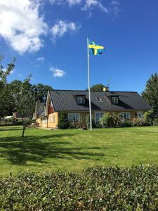 锡姆里斯港Gladsax Gamla Gård的院子前有旗帜的房子