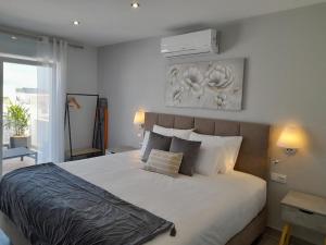 拉戈斯Casa Paula Apartments的一间卧室配有一张带两盏灯的大型白色床。