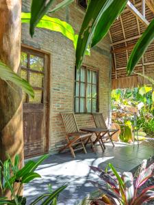 巴图卡拉Coconut Tree Cottages的庭院配有两把椅子和一张桌子