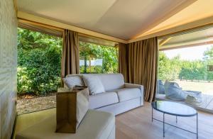 斯培基奥拉Infinito Resort的带沙发和玻璃桌的客厅