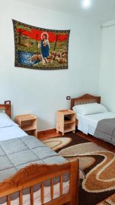 泰斯Bujtina Kometa的一间设有两张床的房间和墙上挂毯