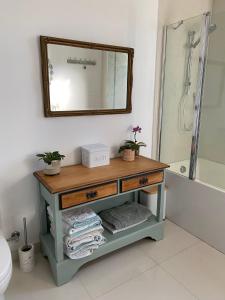 PomonaPomona Noosa Hinterland Homestay的浴室设有一张带镜子的桌子和一个浴缸