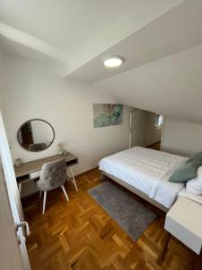 克鲁舍瓦茨Apartman MIA Centar的一间卧室配有一张床、一张书桌和一面镜子