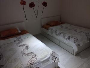 帕拉塔蒙platamon 3 platania的墙上有红色鲜花的房间里,有两张床