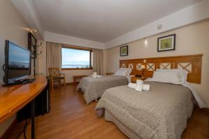 乌斯怀亚Altos Ushuaia Hotel & Resto的酒店客房设有两张床和一台平面电视。