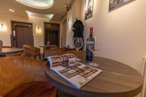 米什科尔茨米什科尔茨城酒店的一张带两杯酒和一瓶葡萄酒的木桌