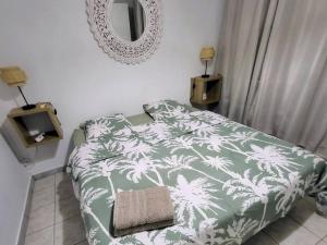 哥西尔Appartement magnifique vue mer的卧室配有绿色和白色的床和镜子