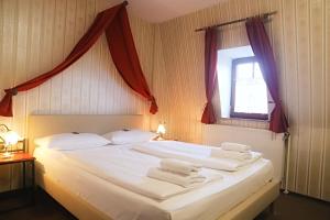 罗滕堡Hotel Schwarzer Adler的卧室配有带毛巾的大型白色床