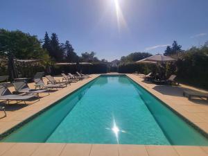 圣吉尔Domaine du Prieuré d'Estagel的一个带躺椅的游泳池和一个游泳池