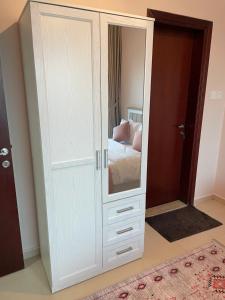 阿吉曼One bedroom new brand in ajman的卧室内带镜子的白色橱柜