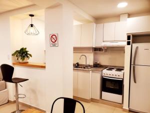 里奥格兰德House Rental RG_Departamento#1的厨房配有白色橱柜、水槽和冰箱。