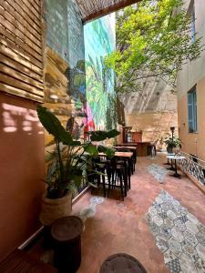 雅典Baloo Hostel的一个带桌椅的庭院和墙上的绘画