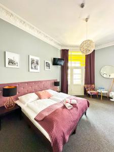 波兹南Expolis Residence - City Center MTP TARGI - 24h #betterthanyourEX的一间卧室配有一张带粉色毯子的大床