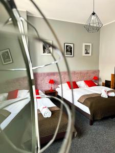 波兹南Expolis Residence - City Center MTP TARGI- Reception 24h的一间卧室配有两张带红色枕头的床