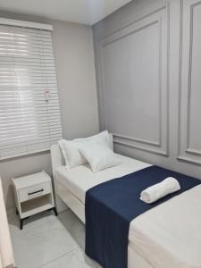 马普托Pousada Calma的白色的客房设有两张床和窗户。