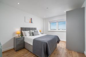 伦敦Skyvillion - London River Thames Top Floor Apartments by Woolwich Ferry, Mins to London ExCel, O2 Arena , London City Airport with Parking的一间卧室设有一张大床和一个窗户。