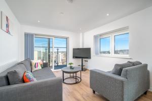 伦敦Skyvillion - London River Thames Top Floor Apartments by Woolwich Ferry, Mins to London ExCel, O2 Arena , London City Airport with Parking的客厅配有两张沙发和一台电视机