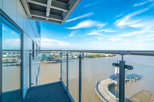 伦敦Skyvillion - London River Thames Top Floor Apartments by Woolwich Ferry, Mins to London ExCel, O2 Arena , London City Airport with Parking的阳台位于大楼内,享有水景