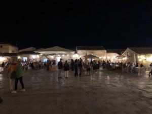 马尔扎梅米Sea House的一群人晚上站在广场上