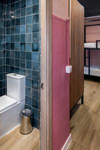 瓦伦西亚SOM Hostel By The Venue的一间带卫生间和粉红色门的浴室