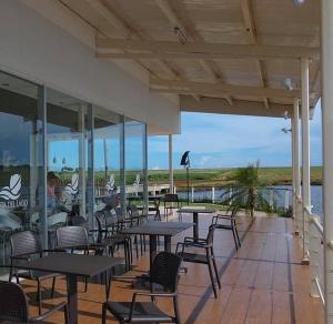 HernandariasPaz y Armonía: Con Playa Privada的一间带桌椅并享有水景的餐厅