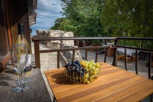 索佐波尔Къща за гости Димови的桌上一篮水果和一杯葡萄酒