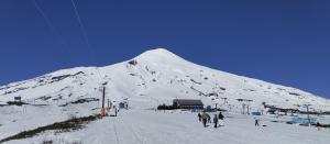 普孔Hotel Enjoy Pucon的一群人在雪覆盖的山上滑雪