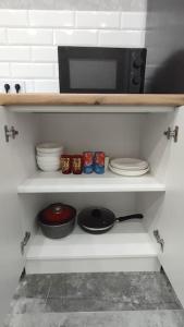巴甫洛达尔Люкс апартаменты в ЖК Shanyrak的厨房里摆放着碗碟和微波炉的架子